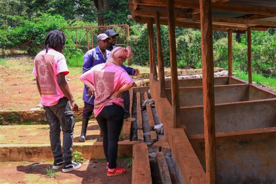 Founders and station staff beside the fermentation tanks at a coffee washing station