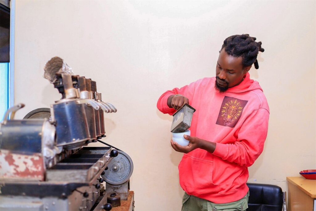 A Mambo Leo founder operating a sample roaster