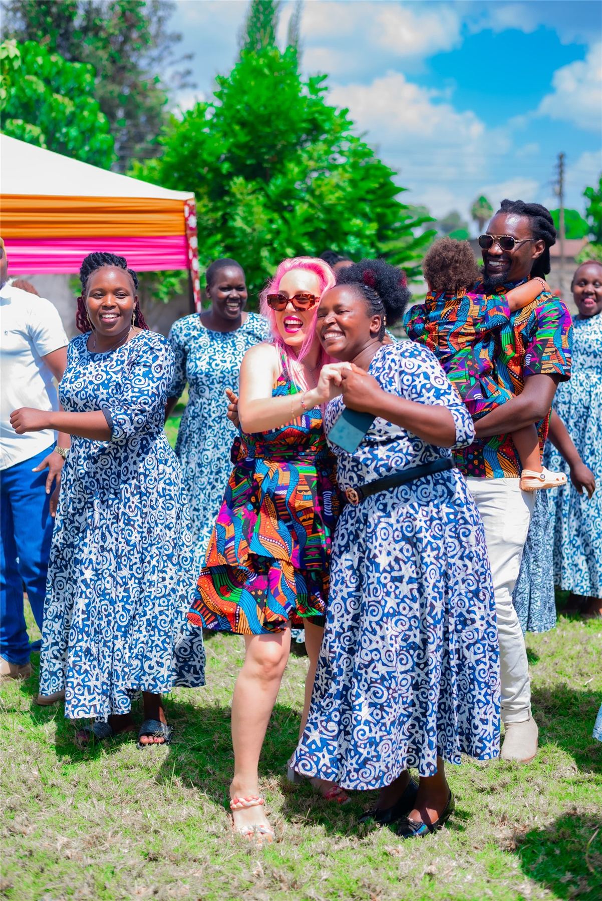 Members of a Kenyan women's group in matching dresses with a Mambo Leo founder